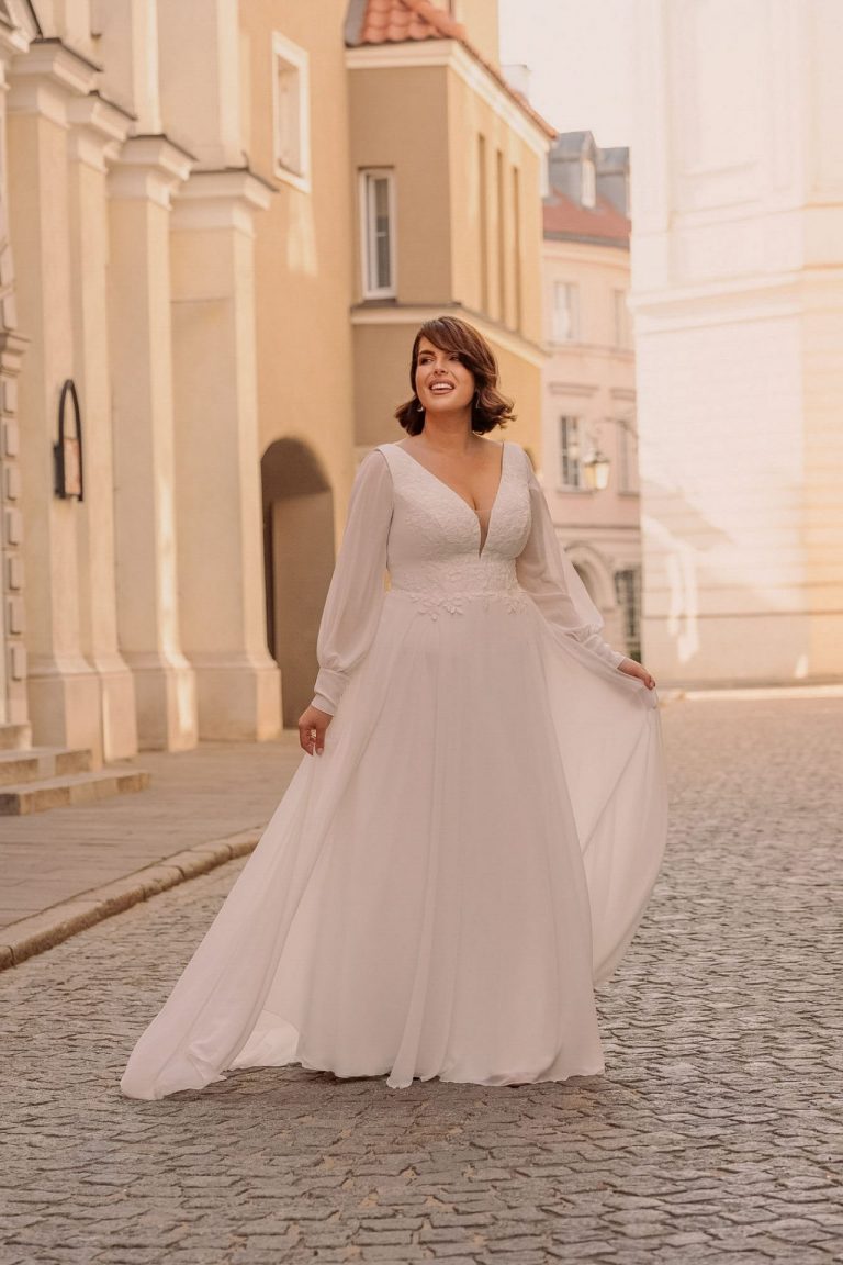 Brautkleid mit langen Ärmeln und floralen Stickereien, fließender Chiffonrock in A-Linie, perfekt für romantische Hochzeiten.
