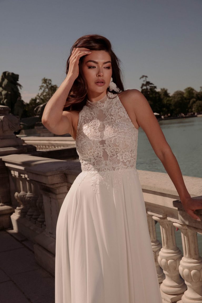 Hochgeschlossenes Brautkleid aus Spitze mit fließendem Chiffonrock, Vorderansicht.