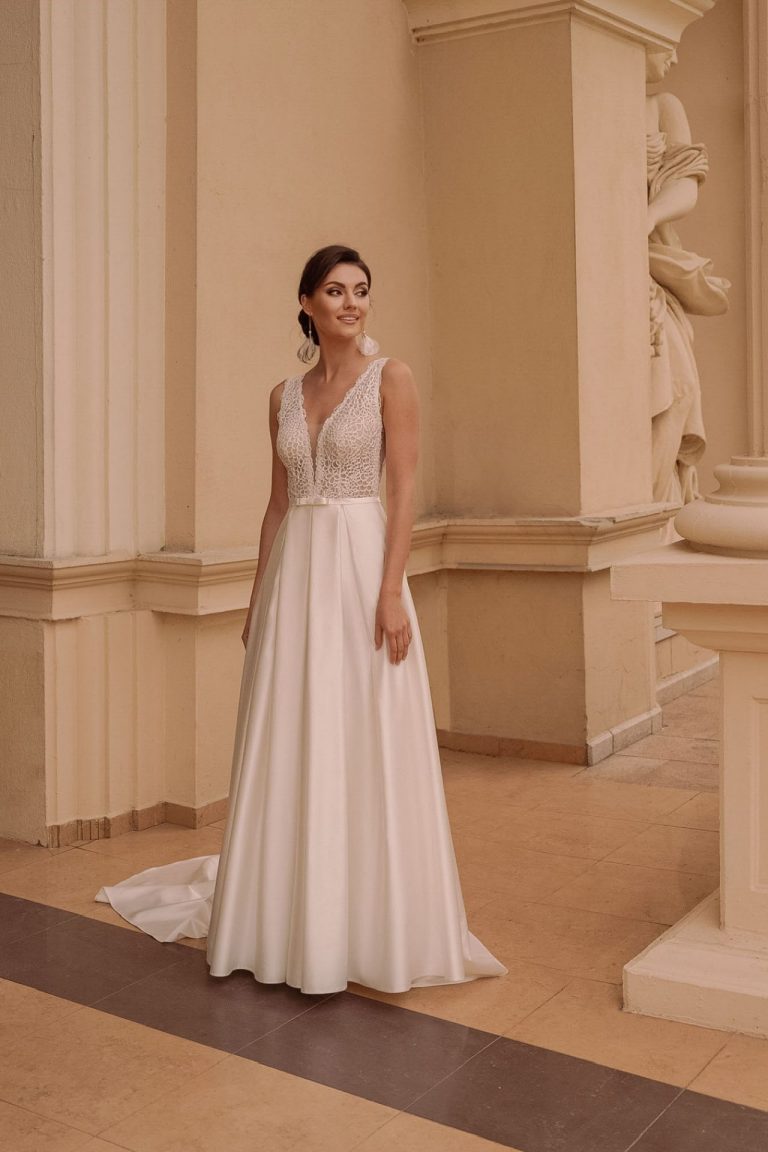Braut in einem A-Linien-Brautkleid mit Spitzenoberteil und fließendem Satinrock, Frontansicht